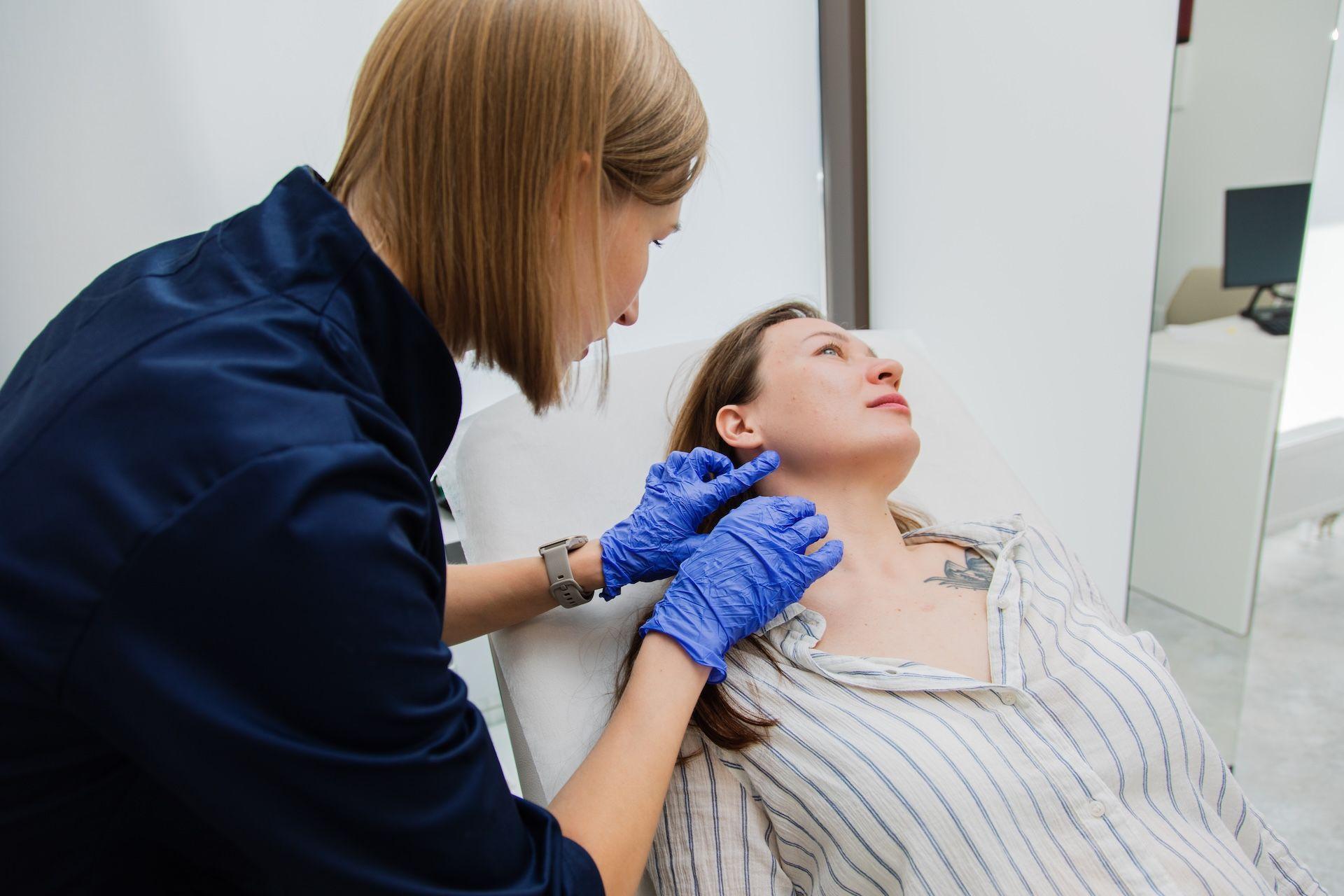 дерматолог оглядає шкіри шиї жінці