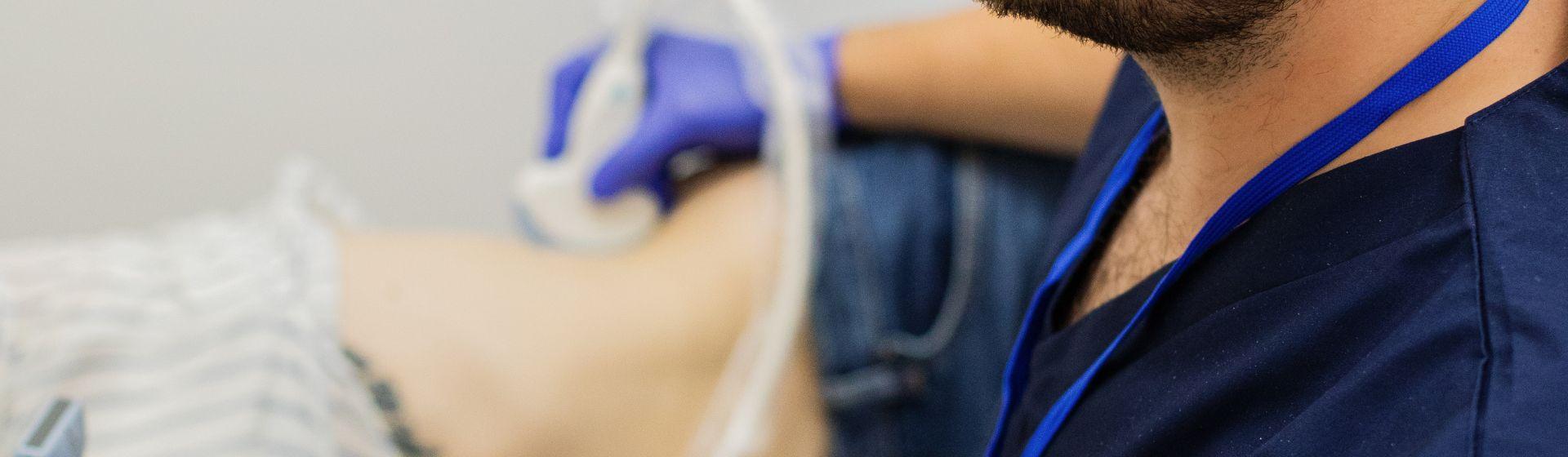 лікар проводить узд черевної порожнини жінці